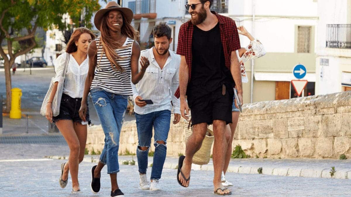  Group of young people walking on a vacation booked through a travel rewards program.
