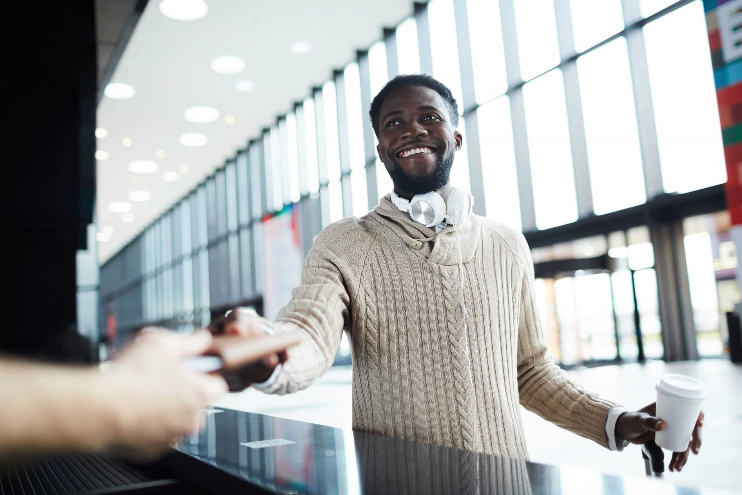 Man checking in at an airport counter using rewards benefits