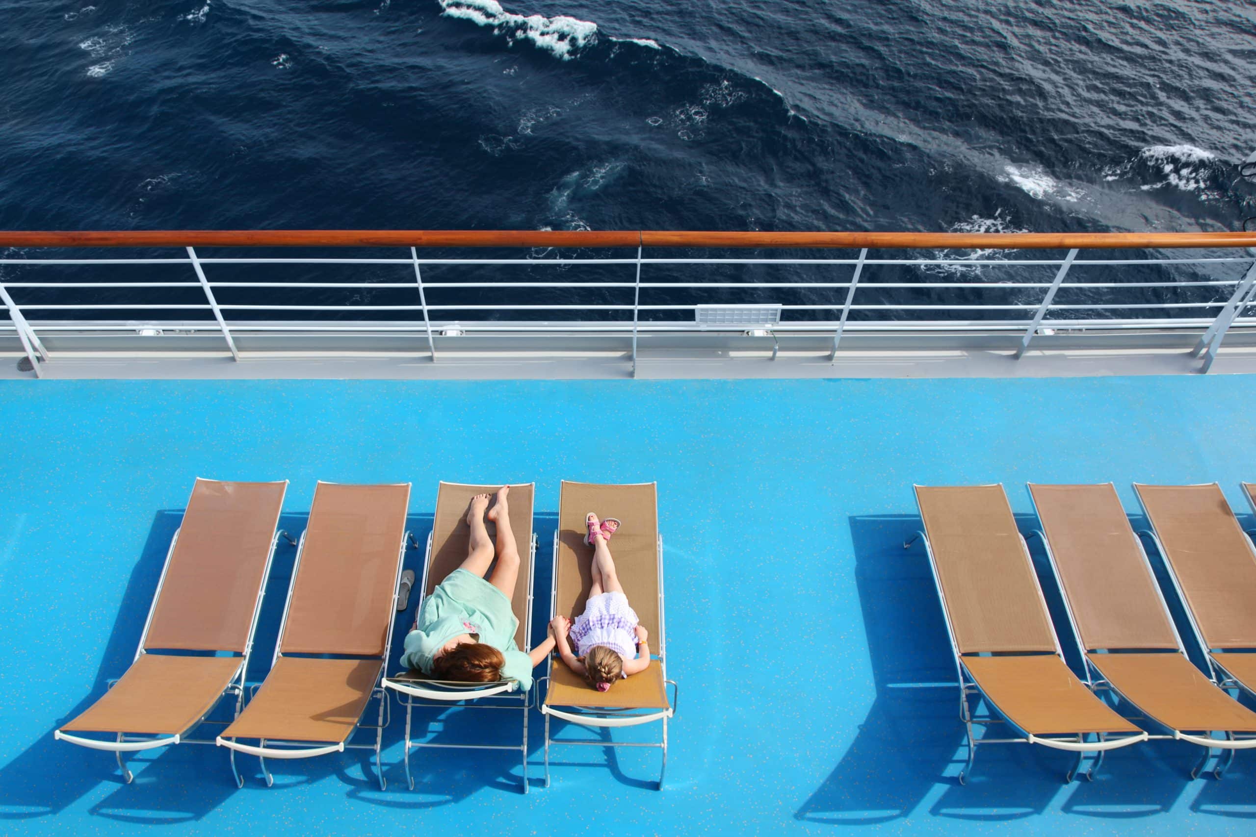 Top view of mother and daughter lounging on a cruise ship deck by the ocean